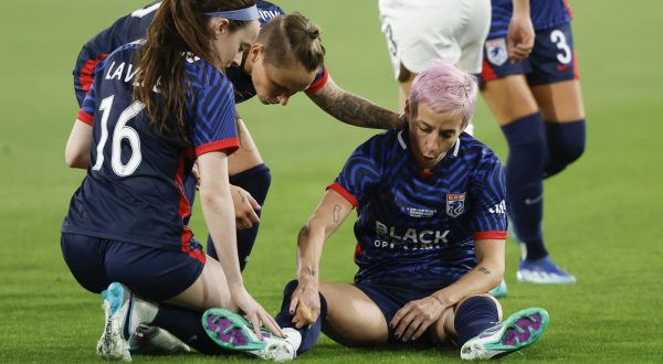 epa10970926 Megan Rapinoe of OL Reign (R) sits on the pitch after an injury during the NWSL Championship match between OL Reign and Gotham FC at Snapdragon Stadium in San Diego, California, USA, 11 November 2023.  EPA/CAROLINE BREHMAN