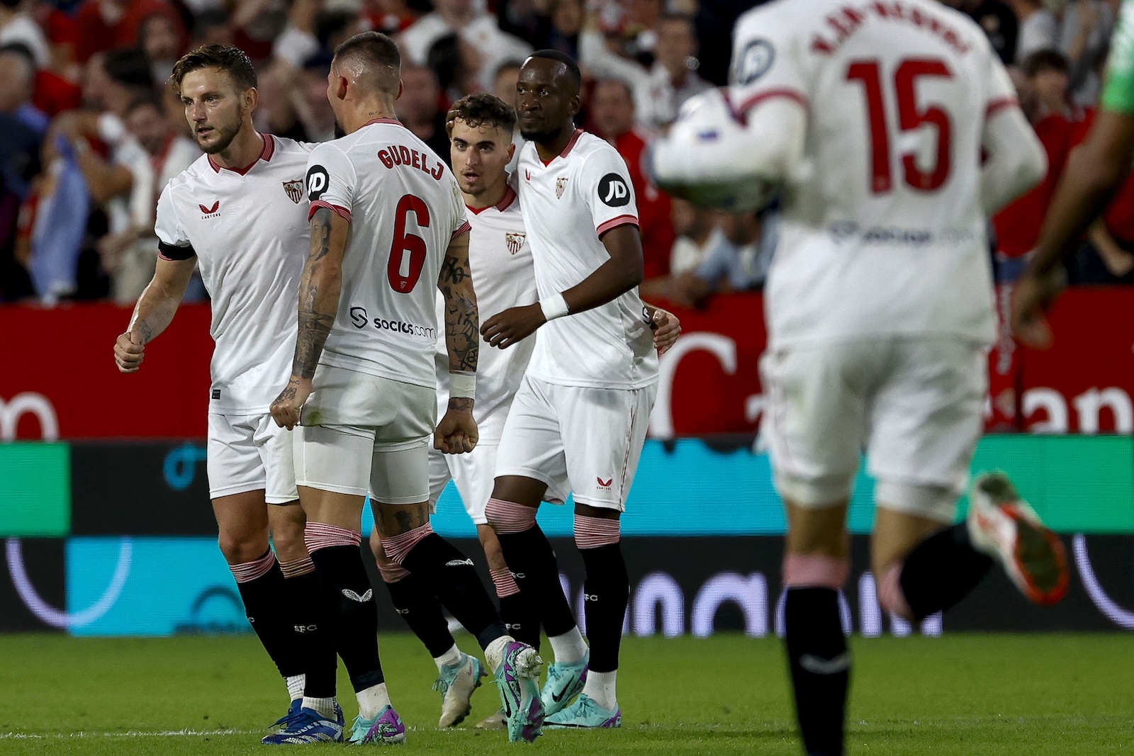 epa10972345 Sevilla's midfielder Ivan Rakitic (L) celebrates with teammates after scoring the 1-1 goal during the Spanish LaLiga soccer match between Sevilla FC and Real Betis, in Seville, southern Spain, 12 November 2023.  EPA/Julio Munoz