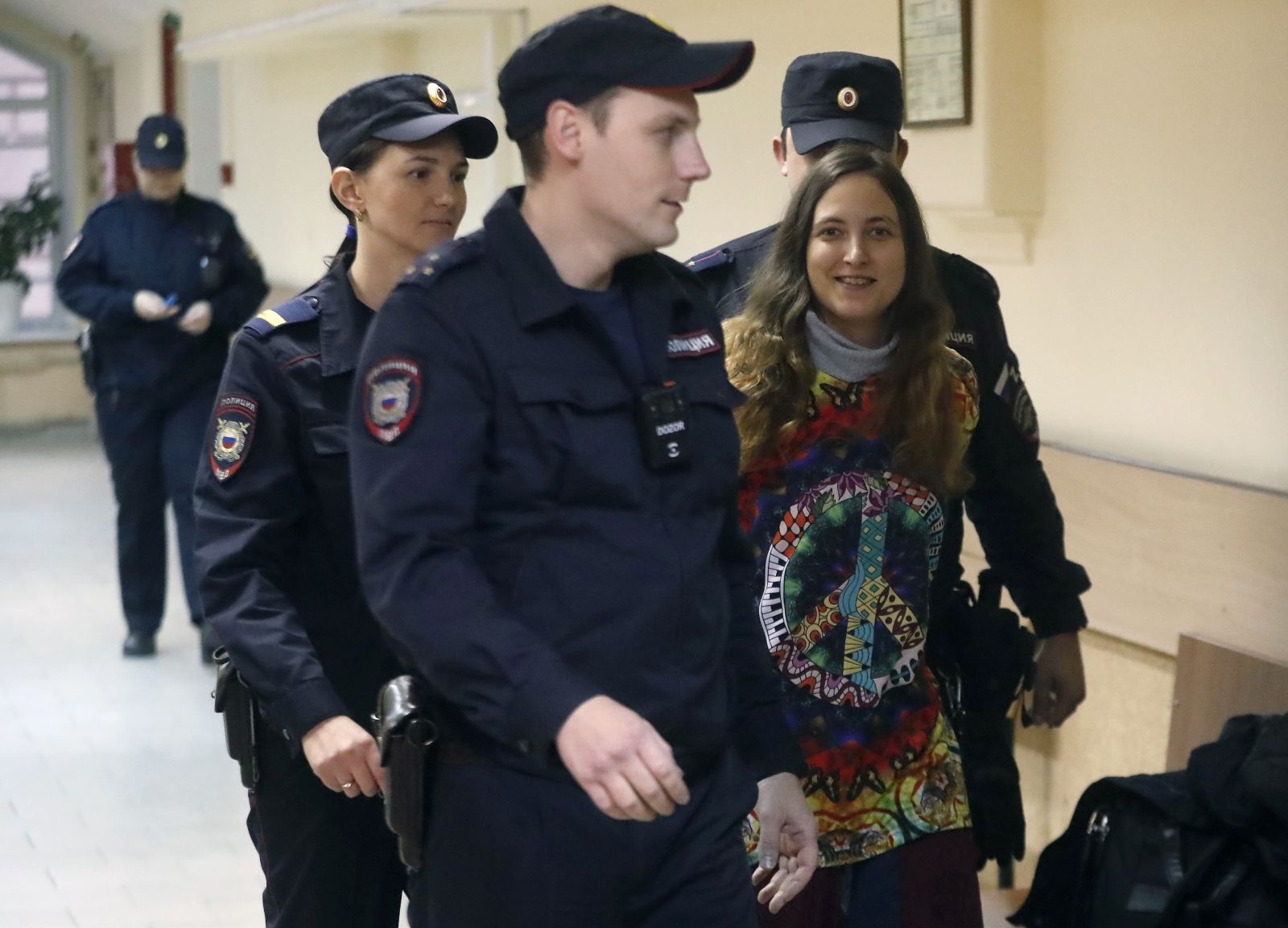 epa10973095 Russian artist and musician, 33-years old Sasha Skochilenko (R), is escorted by police officers to the courtroom for a hearing in the Vasileostrovsky district court in St. Petersburg, Russia, 13 November 2023. Sasha Skochilenko was arrested in April 2022 and faces charges of spreading false information about the army after replacing supermarket price tags with slogans protesting against Russia's military operation in Ukraine.  EPA/ANATOLY MALTSEV