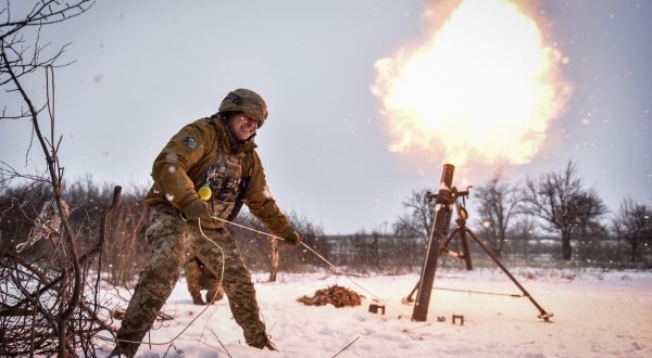 epa10997252 Ukrainian serviceman of the 24-th separate mechanized brigade named after King Danylo" fires a mortar towards Russian positions, at an undisclosed location, Donetsk region, eastern Ukraine, 17 February 2023.  EPA/OLEG PETRASYUK