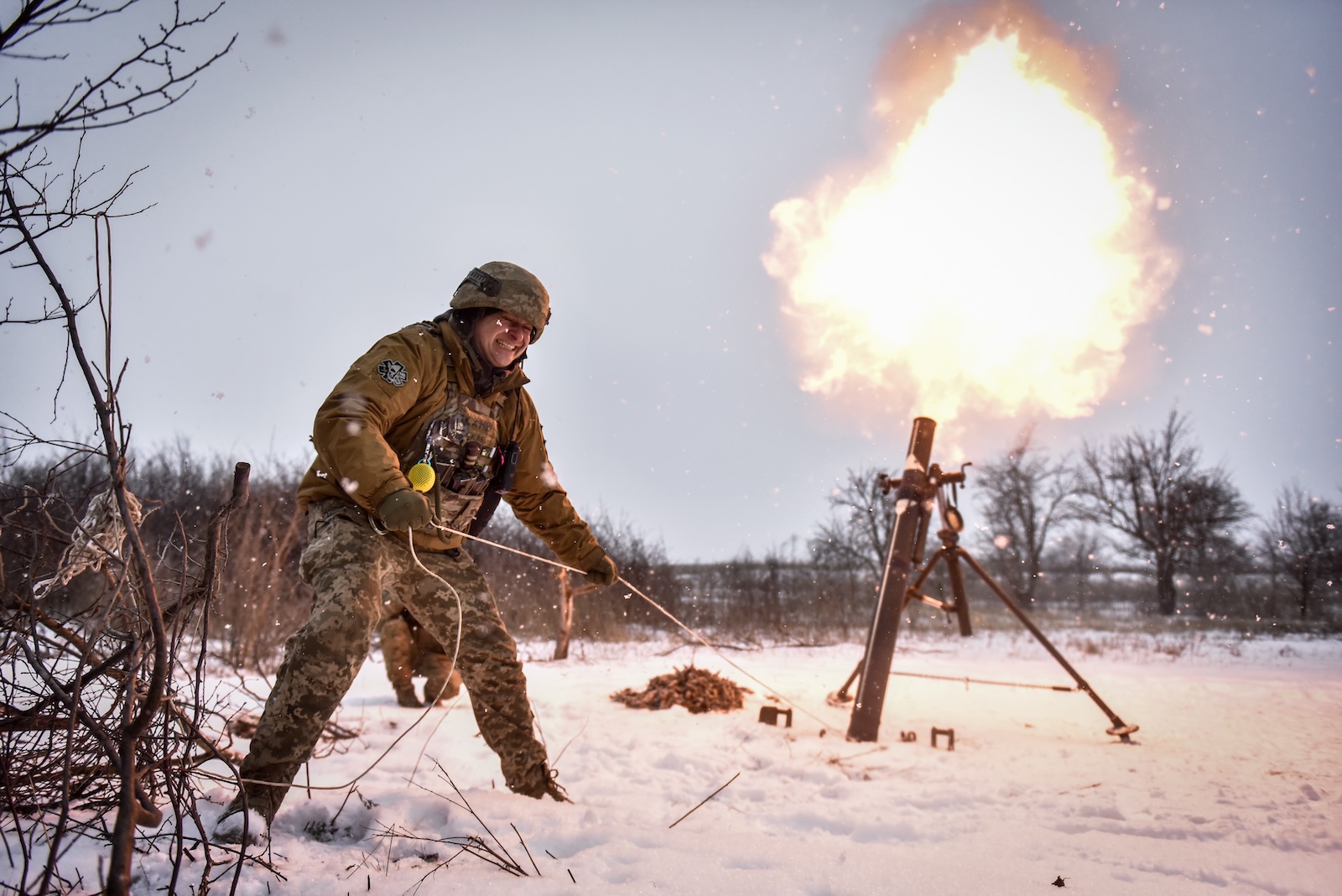 epa10997252 Ukrainian serviceman of the 24-th separate mechanized brigade named after King Danylo" fires a mortar towards Russian positions, at an undisclosed location, Donetsk region, eastern Ukraine, 17 February 2023.  EPA/OLEG PETRASYUK