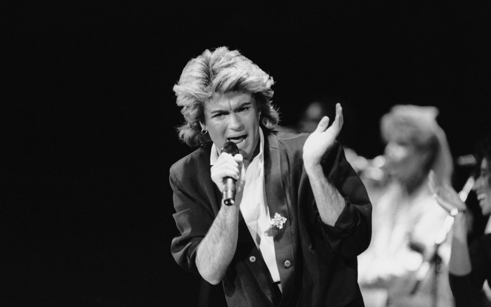 Wham! singer George Michael performs for a capacity crowd in Peking in China's first big-name rock concert, April 7, 1985. The group's music has been officially labeled "healthy" in China's changing society, where Western pop music was considered banal and filthy. (AP Photo/Neal Ulevich)