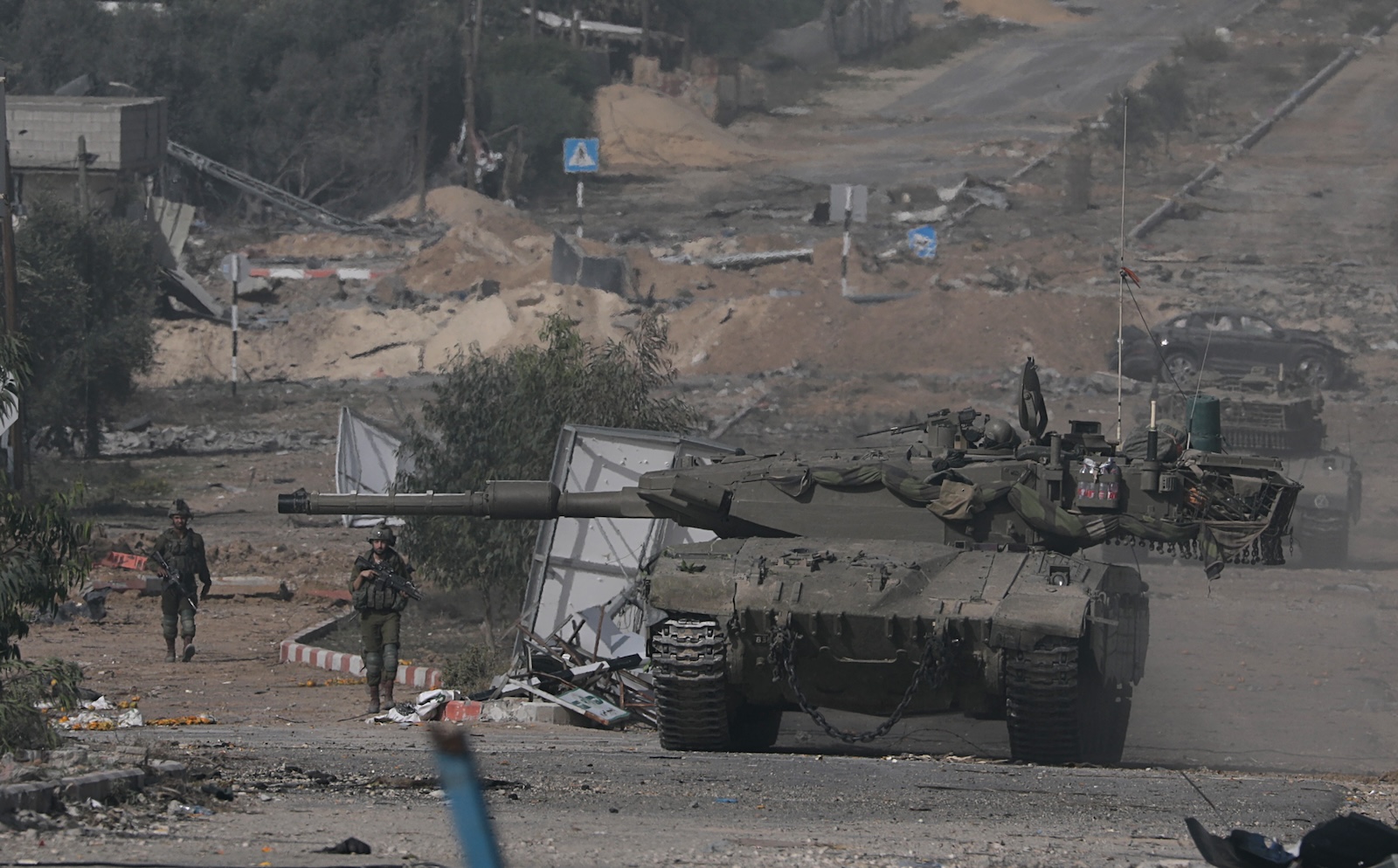 epa10996169 Israeli tanks move along Salah Al Din road in the central Gaza Strip, 26 November 2023. After Israel and Hamas agreed to a four-day ceasefire, mediated by Qatar, the US, and Egypt, that came into effect at 05:00 AM GMT on 24 November, some Palestinians who were still in central Gaza moved towards the south while others already displaced in the south went back to the northern part to check on relatives they had left behind and on their homes to collect salvageable belongings. As part of the ceasefire, the agreement included that 50 Israeli hostages, women and children, are to be released by Hamas. 150 Palestinian women and children that were detained in Israeli prisons are to be released in exchange.  EPA/MOHAMMED SABER