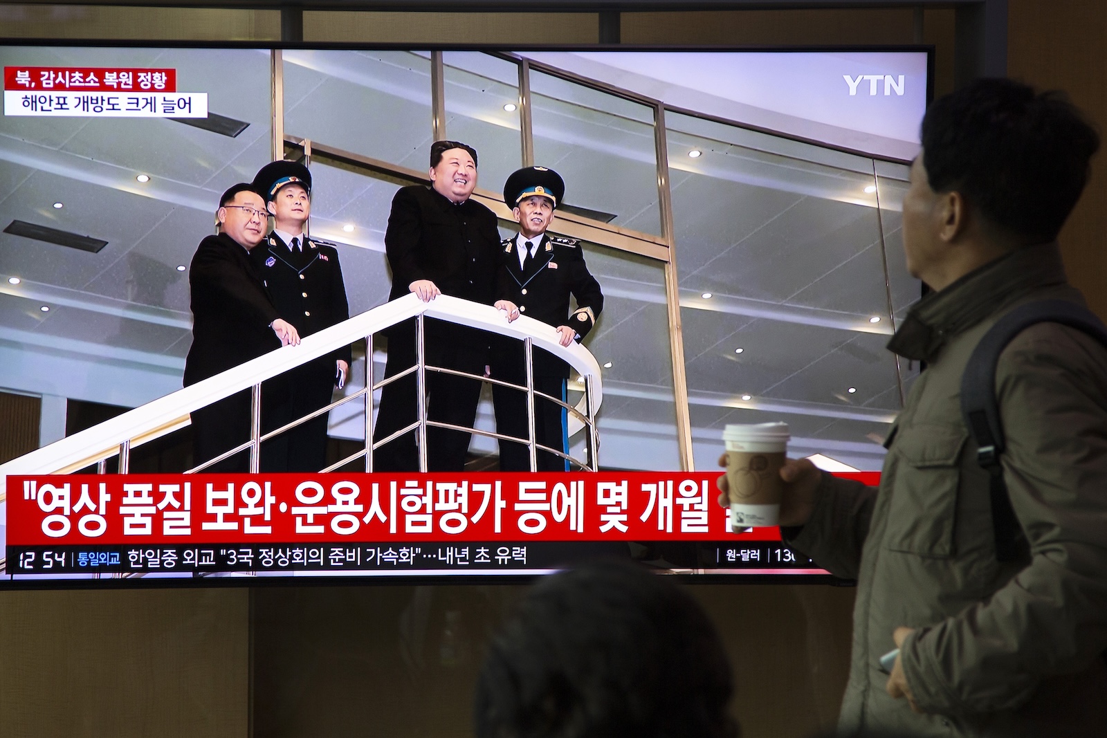epa10997121 People watch as North Korean Leader Kim Jong Un appears on a TV monitor displaying daily news at a station in Seoul, South Korea, 27 November 2023. According to a statement by South Korean military officials made on 27 November, North Korea deployed troops and equipment to Demilitarized Zone (DMZ) ground posts after the North vowed to resume all military measures halted under a 2018 deal.  EPA/JEON HEON-KYUN
