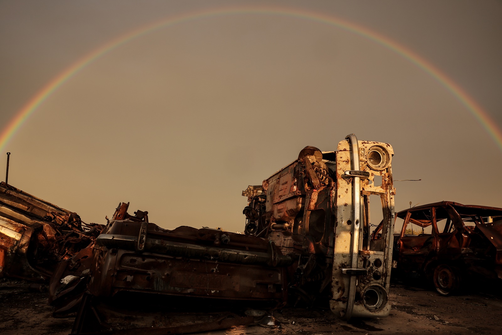 epa10997233 A rainbow over destroyed vehicles in the village of Posad-Pokrovske in the Kherson region, 01 November 2023. Russian troops entered Ukrainian territory in February 2022, starting a conflict that has provoked destruction and a humanitarian crisis.  EPA/OLEG PETRASYUK