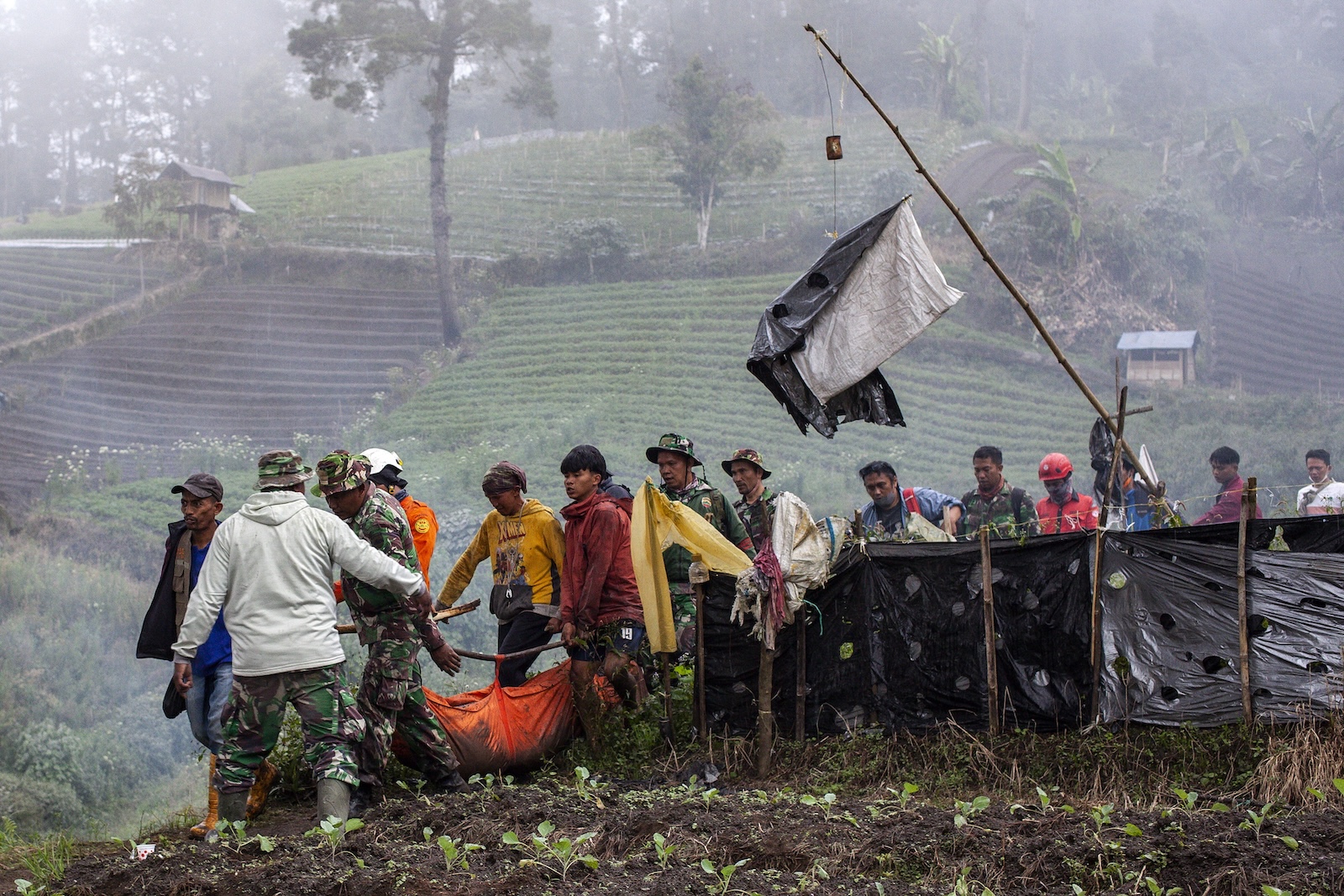 epa11011717 Rescuers carry the body of a hiker killed in the Mount Marapi eruption in Agam, West Sumatra, Indonesia, 05 December 2023. At least 22 hikers were found dead following the Marapi volcano eruption on 03 December 2023, according to the Indonesian rescue agency. Search operations for one missing hiker continue.  EPA/GIVO ALP