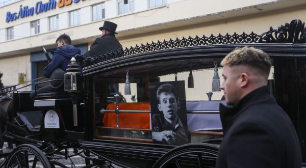 epa11017264 The hearse during the public funeral procession for Shane MacGowan in Dublin, Ireland, 08 December 2023. The funeral mass will take place in Nenagh, Co Tipperary later in the day for the Pogues' singer who died on 30 November 2023 aged 65 following a period of ill health.  EPA/MOSTAFA DARWISH