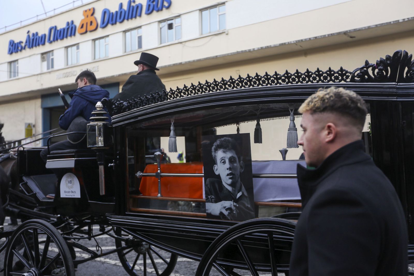 epa11017264 The hearse during the public funeral procession for Shane MacGowan in Dublin, Ireland, 08 December 2023. The funeral mass will take place in Nenagh, Co Tipperary later in the day for the Pogues' singer who died on 30 November 2023 aged 65 following a period of ill health.  EPA/MOSTAFA DARWISH