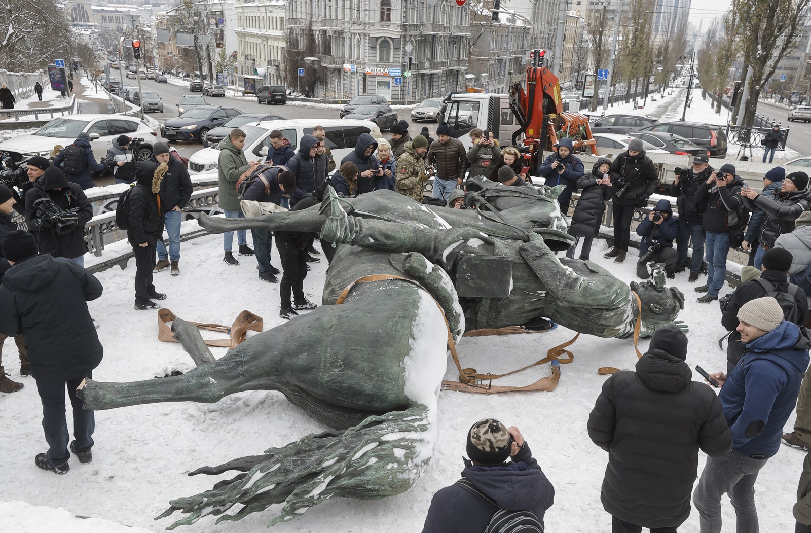 epa11019227 Visitors and journalists follow the dismantling of the monument of Mykola Shchors, a Red Army commander in the civil war of 1918-1921, in Kyiv, Ukraine, 09 December 2023 amid the Russian invasion. The monument is removed after the Ministry of Culture and Information Policy announced that it is not subject to entry into the state register of immovable monuments of Ukraine and allowed for it to be taken down, being a symbol of the Soviet era.  EPA/SERGEY DOLZHENKO