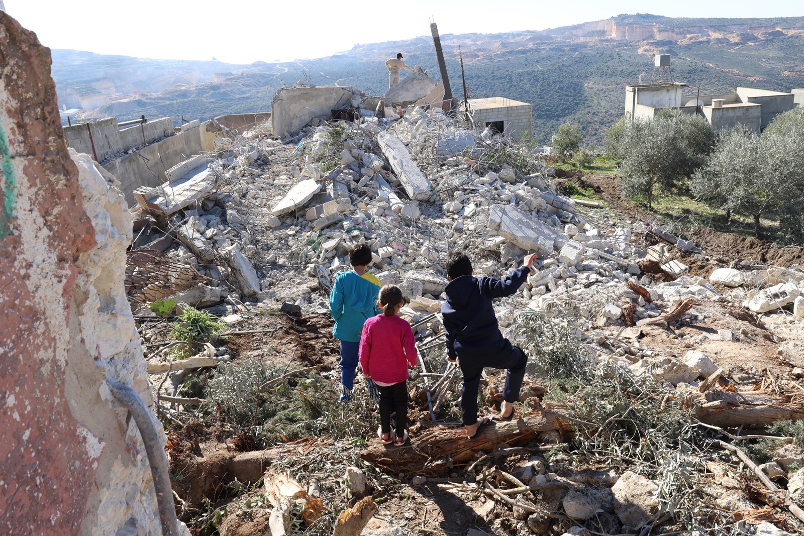 epa11031271 Palestinian children inspect the rubble of the home of the family of Hamed Sabbah in Urif village, south of the West Bank city of Nablus, 15 December 2023. The Israeli army demolished the houses of Ziad Jibril Al-Safadi and Hamed Sabbah, two alleged gunmen named responsible for a shooting attack near the West Bank settlement of Eli in June that killed four Israelis.  EPA/ALAA BADARNEH