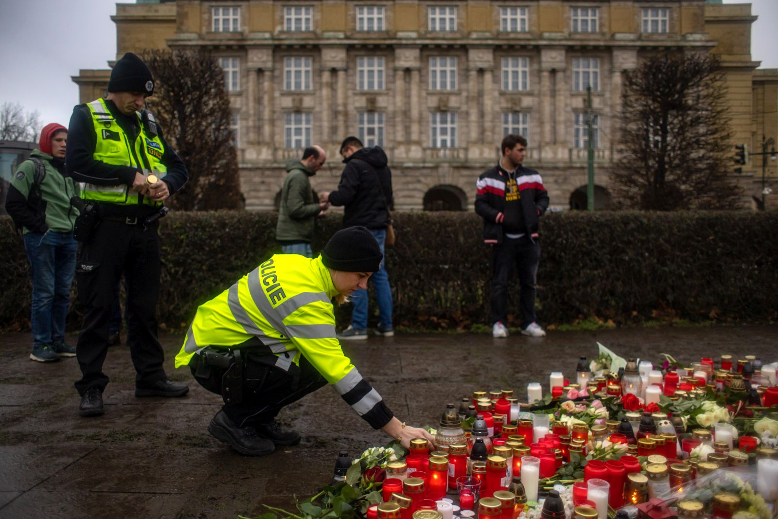 epa11040903 A police officer pays respects outside the Faculty of Philosophy building at Charles University following a mass shooting in central Prague, Czech Republic, 22 December 2023. According to the Czech Police President Martin Vondrasek, there are at least 14 people dead and 25 injured after the shooting at the Charles University on 21 December. According to Czech police the perpetrator was a 24 year-old Charles University student, who is also suspected of killing his father.  EPA/MARTIN DIVISEK