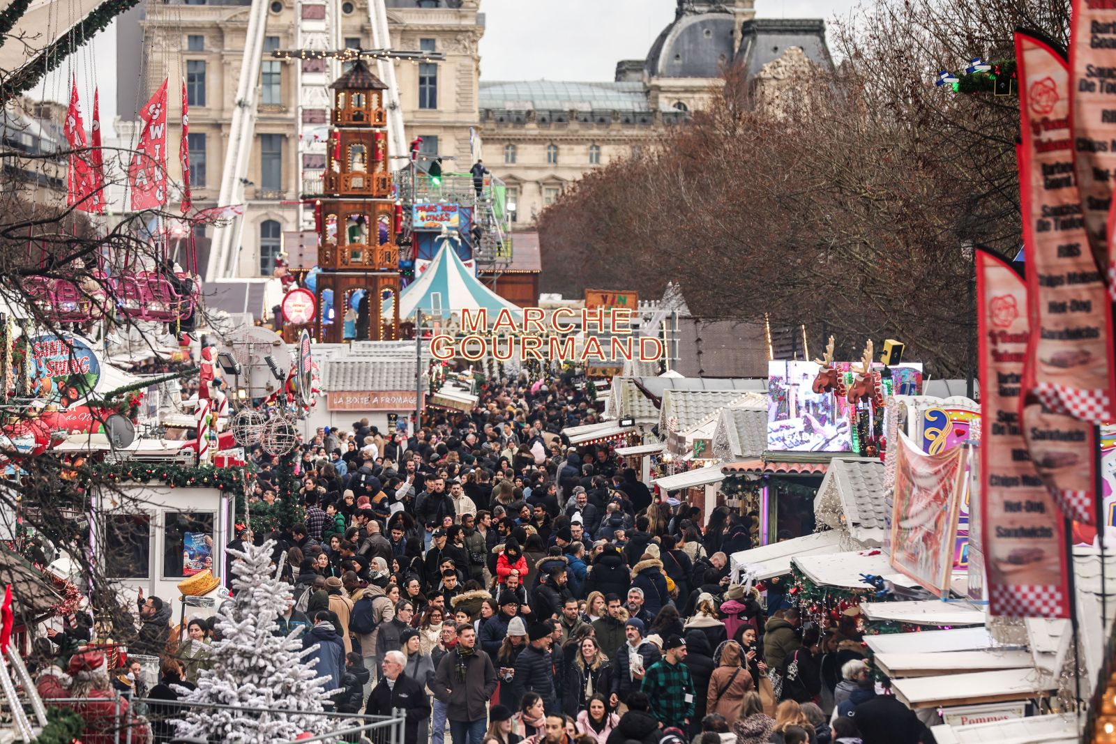 epa11042513 People throng the Christmas market in the Tuileries Garden as they visit attractions and various stalls, in Paris, France, 23 December 2023. The market opened to the public on 18 November 2023 and runs through 07 January 2024.  EPA/TERESA SUAREZ