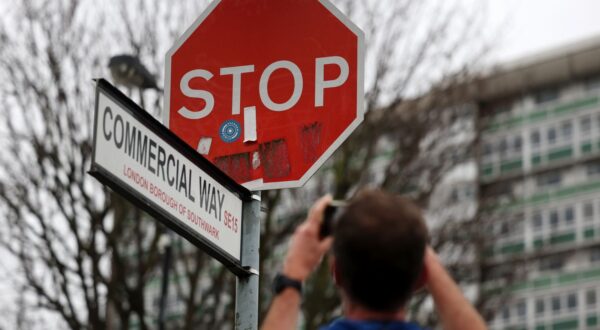 epa11042902 A local Londoner photographs a replaced Stop sign at Commercial Way in Peckham south London, Britain, 24 December 2023. A Stop sign has been replaced at the scene of a stolen Banksy Stop sign artwork depicting flying military drones. A man has been arrested after removing the Banksy artwork in south London on 22 December, the London police said.  EPA/ANDY RAIN