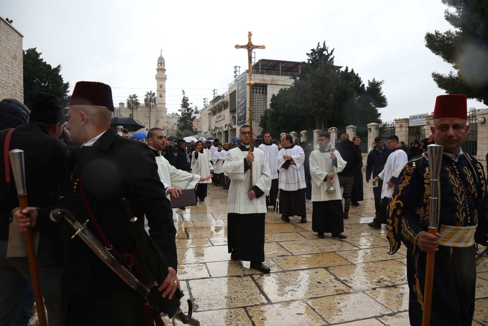 epa11042952 Catholic clergy walk in procession at Manger Square, leading to the Church of the Nativity,  in the West Bank town of Bethlehem, 24 December 2023. Church leaders in the historical Christian town of Bethlehem, traditionally revered as the birthplace of Jesus, have announced the cancelation of public Christmas celebrations this year in solidarity with the people of Gaza amid the ongoing Israel-Gaza conflict. Christmas activities will be limited to worship and prayer, without the usual Christmas lights and tree.  EPA/Wisam Hashlamoun