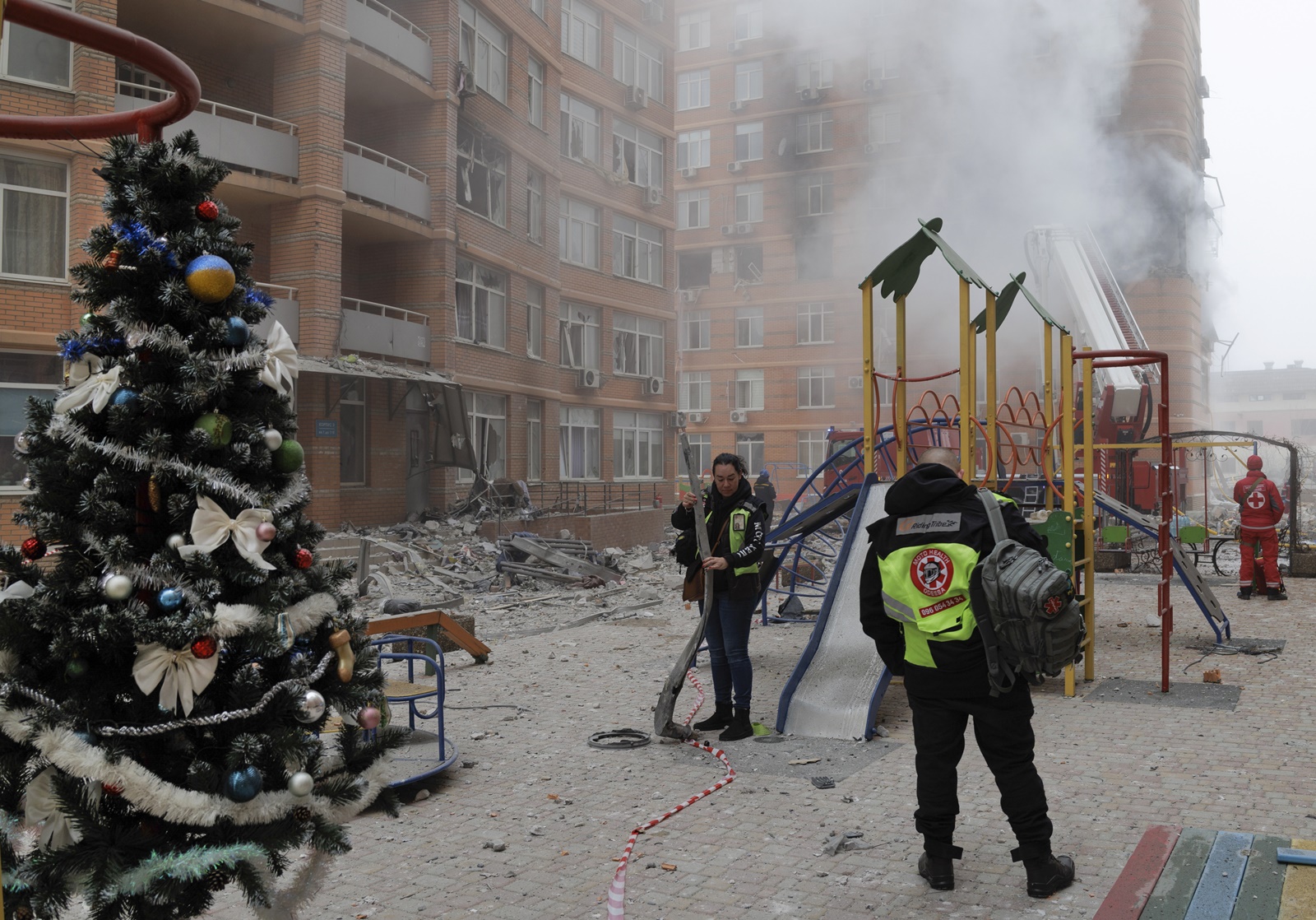 epa11048265 A Christmas tree near a playground as Ukrainian rescuers and police officers work at the site of a damaged residential building after shelling in Odesa, southwestern Ukraine, 29 December 2023, amid the Russian invasion. At least 18 people have died and over 130 were injured after Russia launched a wave of airstrikes across Ukraine, Ukraine's Ministry of Internal Affairs said on 29 December. Strikes were reported in Kyiv, Lviv, Odesa, Dnipro, Kharkiv, Zaporizhzhia, and other Ukrainian cities. Russia launched 'more than 150 missiles and combat drones' at Ukrainian cities, Ukraine's Prosecutor General Andriy Kostin said in a statement, adding that extensive damage included residential buildings, educational institutions and hospitals. Russian troops entered Ukraine on 24 February 2022 starting a conflict that has provoked destruction and a humanitarian crisis.  EPA/IHOR HORA