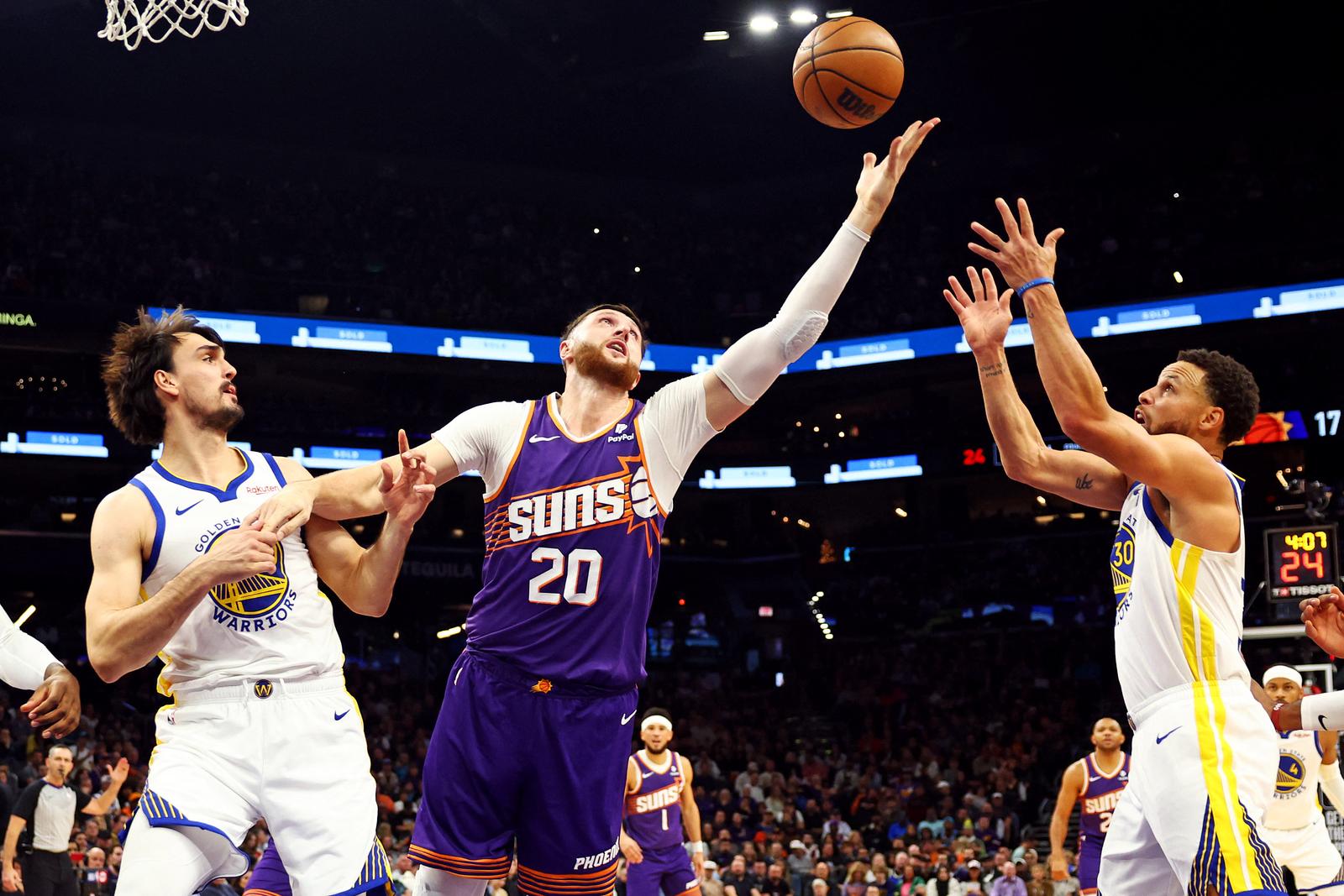 Dec 12, 2023; Phoenix, Arizona, USA; Phoenix Suns center Jusuf Nurkic (20) yes for a rebound against Golden State Warriors forward Dario Saric (20) and guard Stephen Curry (30) during the first quarter at Footprint Center. Mandatory Credit: Mark J. Rebilas-USA TODAY Sports Photo: Mark J. Rebilas/REUTERS