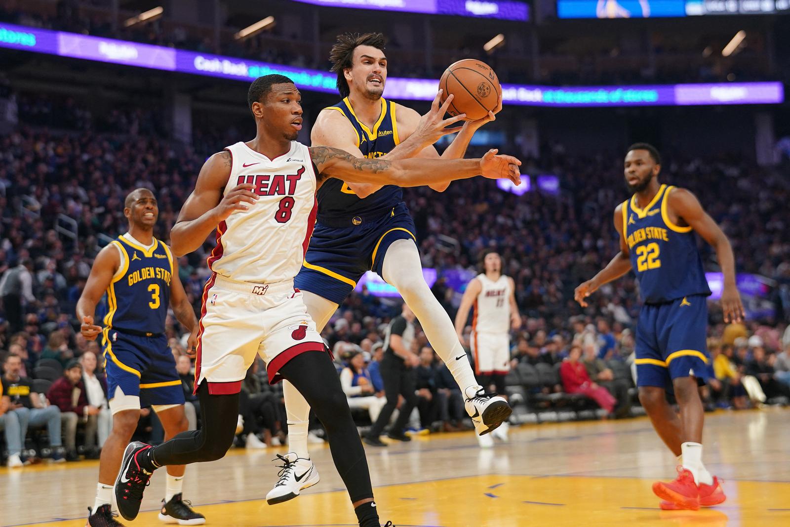 Dec 28, 2023; San Francisco, California, USA; Golden State Warriors forward Dario Saric (20) grabs a rebound next to Miami Heat forward Jamal Cain (8) in the first quarter at the Chase Center. Mandatory Credit: Cary Edmondson-USA TODAY Sports Photo: Cary Edmondson/REUTERS