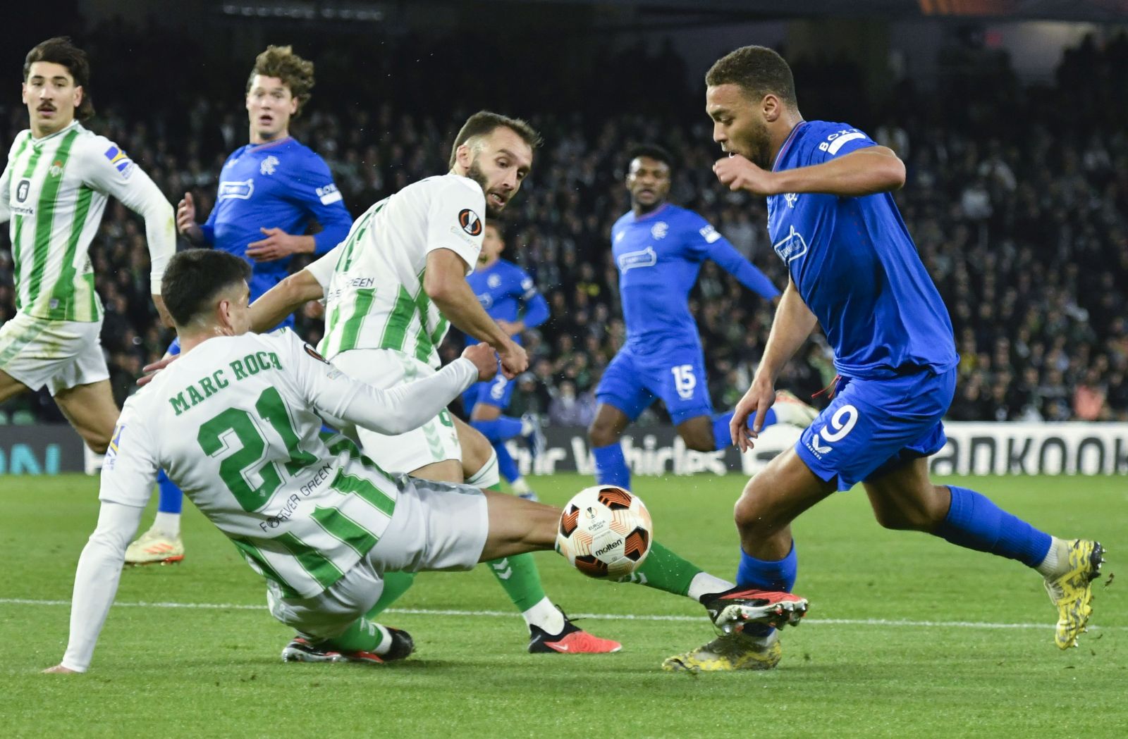 epa11029935 Betis' defender Marc Roca (L) in action against Rangers' striker Cyriel Dessers (R) during the UEFA Europe League group C soccer match between Real Betis and Glasgow Rangers, in Seville, Andalusia, Spain, 14 December 2023.  EPA/Raul Caro