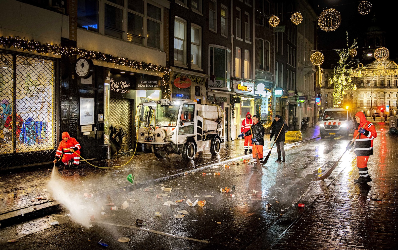 epa11051888 Cleaning crews clean up the remains of New Year's Eve on Damstraat in Amsterdam, the Netherlands, 01 January 2024.  EPA/RAMON VAN FLYMEN