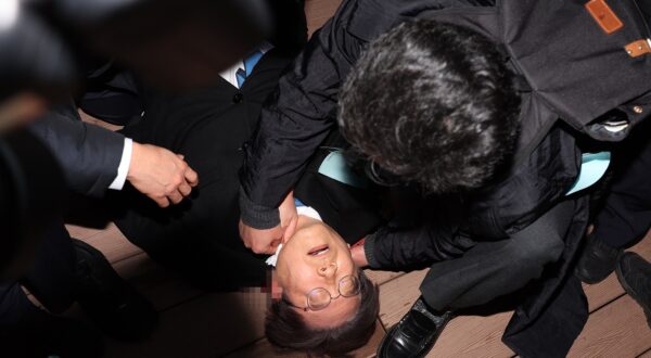epaselect epa11052707 Lee Jae-myung, leader of the main opposition Democratic Party, lies down after he was stabbed by an assailant on the left side of his neck during a visit to the construction site of an airport on Gadeok Island off the southeastern port city of Busan, South Korea, 02 January 2024.  EPA/YONHAP SOUTH KOREA OUT