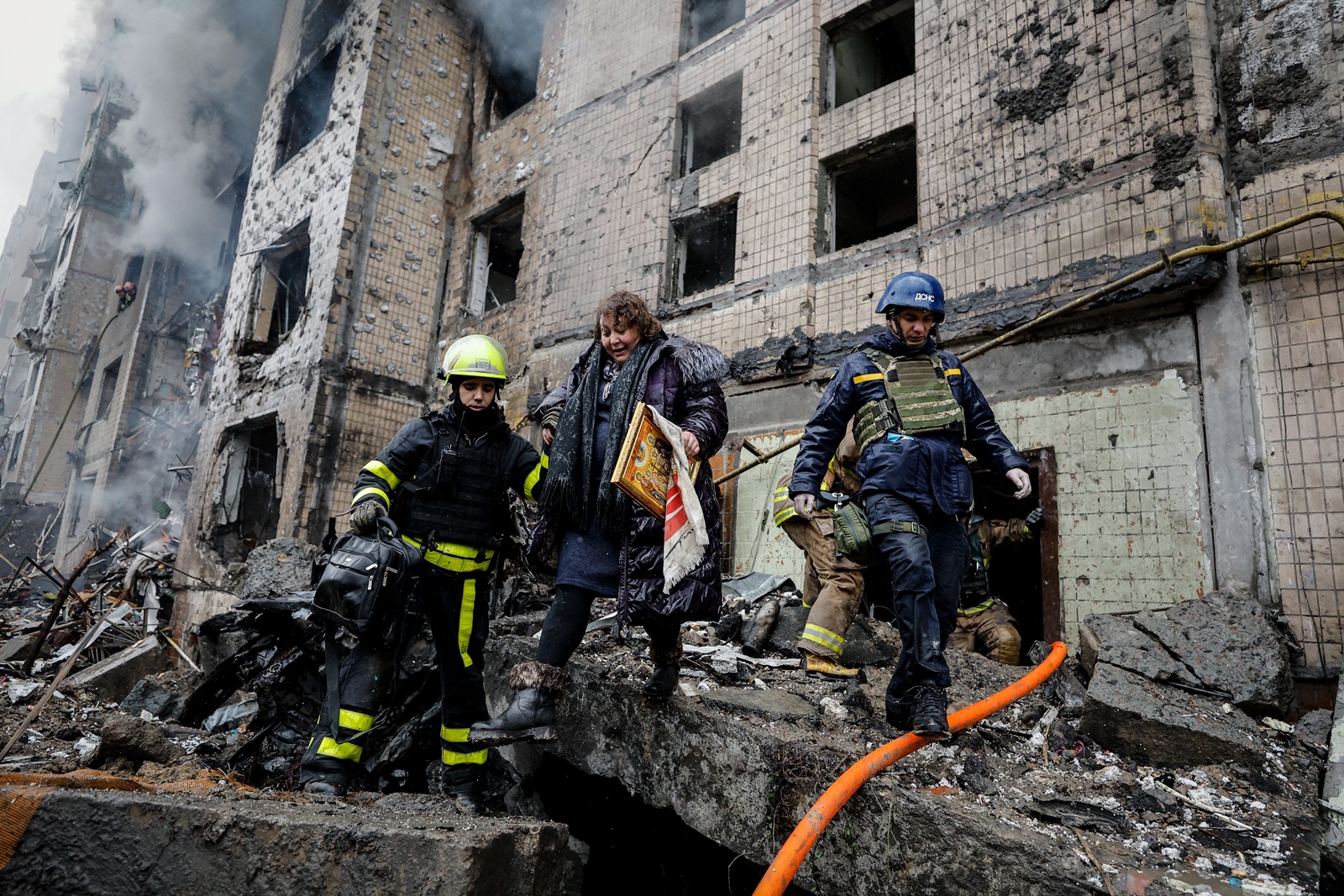 epa11053134 Rescuers evacuate a woman from the site of a damaged building after a missile strike in Kyiv (Kiev), Ukraine, 02 January 2024, amid the Russian invasion. In the early hours of 02 January, Russia launched missile attacks targeting Kyiv and Kharkiv, local officials reported. At least two women were killed, and nearly 70 others were injured in the two cities. In Kyiv, 27 people were hospitalized after a fire broke out in a multi-story building as a result of a rocket attack, the city mayor Vitali Klitschko wrote on telegram, adding that an injured elderly woman died in an ambulance. Some 130 residents were evacuated from the burning building, the State Emergency Service said.  EPA/SERGEY DOLZHENKO