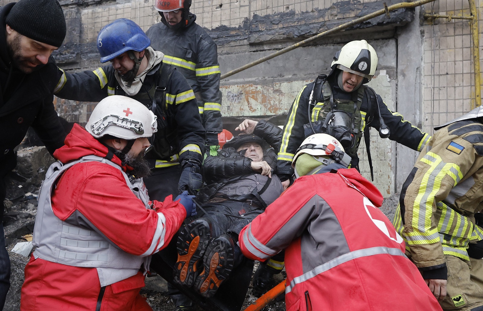 epa11053318 Rescuers and medics evacuate an injured man from the site of a damaged building after a missile strike in Kyiv, Ukraine, 02 January 2024, amid the Russian invasion. In the early hours of 02 January, Russia launched missile attacks targeting Kyiv and Kharkiv, local officials reported. At least two women were killed, and nearly 70 others were injured in the two cities. In Kyiv, 27 people were hospitalized after a fire broke out in a multi-story building as a result of a rocket attack, the city mayor Vitali Klitschko wrote on telegram, adding that an injured elderly woman died in an ambulance. Some 130 residents were evacuated from the burning building, the State Emergency Service said.  EPA/SERGEY DOLZHENKO
