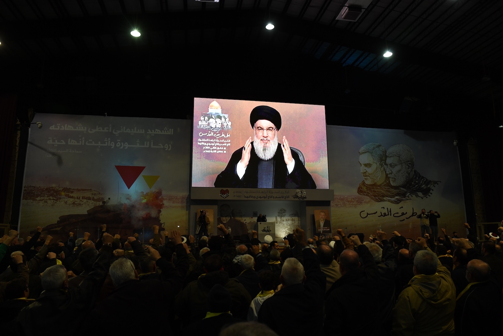 epa11055541 People watch a televised speech of Hezbollah secretary general Hasan Nasrallah, during an event to mark the fourth anniversary of top Iranian commander Qasem Soleimani death, in southern suburb of Beirut, Lebanon, 03 January 2024.  EPA/ABBAS SALMAN