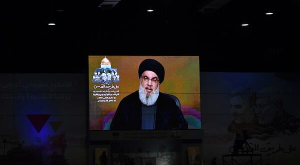 epa11055540 People watch a televised speech of Hezbollah secretary general Hasan Nasrallah, during an event to mark the fourth anniversary of top Iranian commander Qasem Soleimani death, in southern suburb of Beirut, Lebanon, 03 January 2024.  EPA/ABBAS SALMAN
