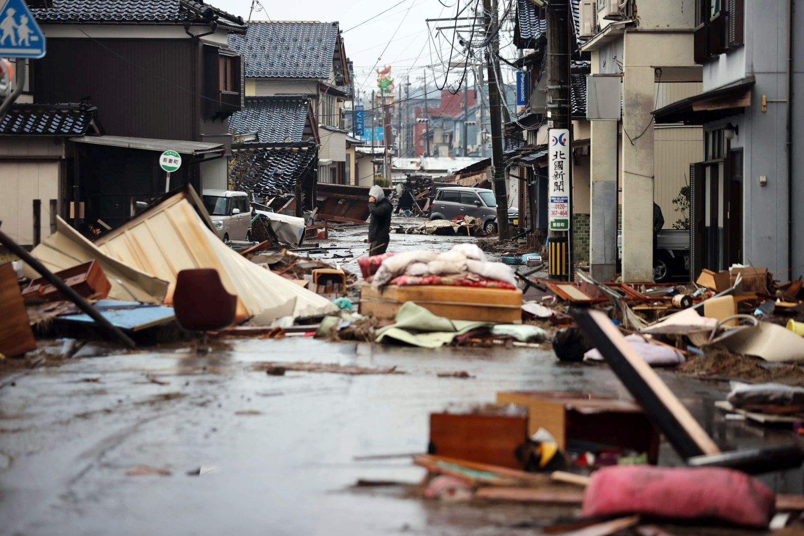 epa11060190 A man stands in a street covered with debris from collapsed houses following an earthquake in Suzu, Ishikawa Prefecture, Japan, 06 January 2024. At least 100 people were killed following a magnitude 7 earthquake (the USGS listed the earthquake as 7.5 magnitude), which occurred on 01 January, according to the Ishikawa Prefecture Government. About 33,000 residents in Ishikawa Prefecture have evacuated to 355 makeshift evacuation centers.  EPA/JIJI PRESS JAPAN OUT EDITORIAL USE ONLY/