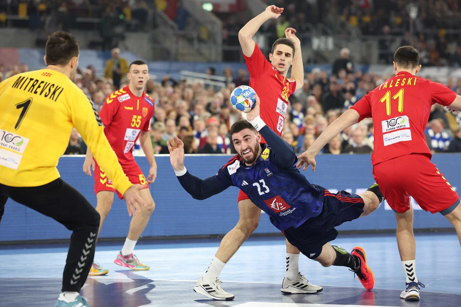 epa11067839 France's Ludovic Fabregas (C) in action against North Macedonia's goalkeeper Nikola Mitrevski (L) during the Men's EHF EURO 2024 Handball preliminary round group A match between France and North Macedonia in Duesseldorf, Germany, 10 January 2024.  EPA/Christopher Neundorf