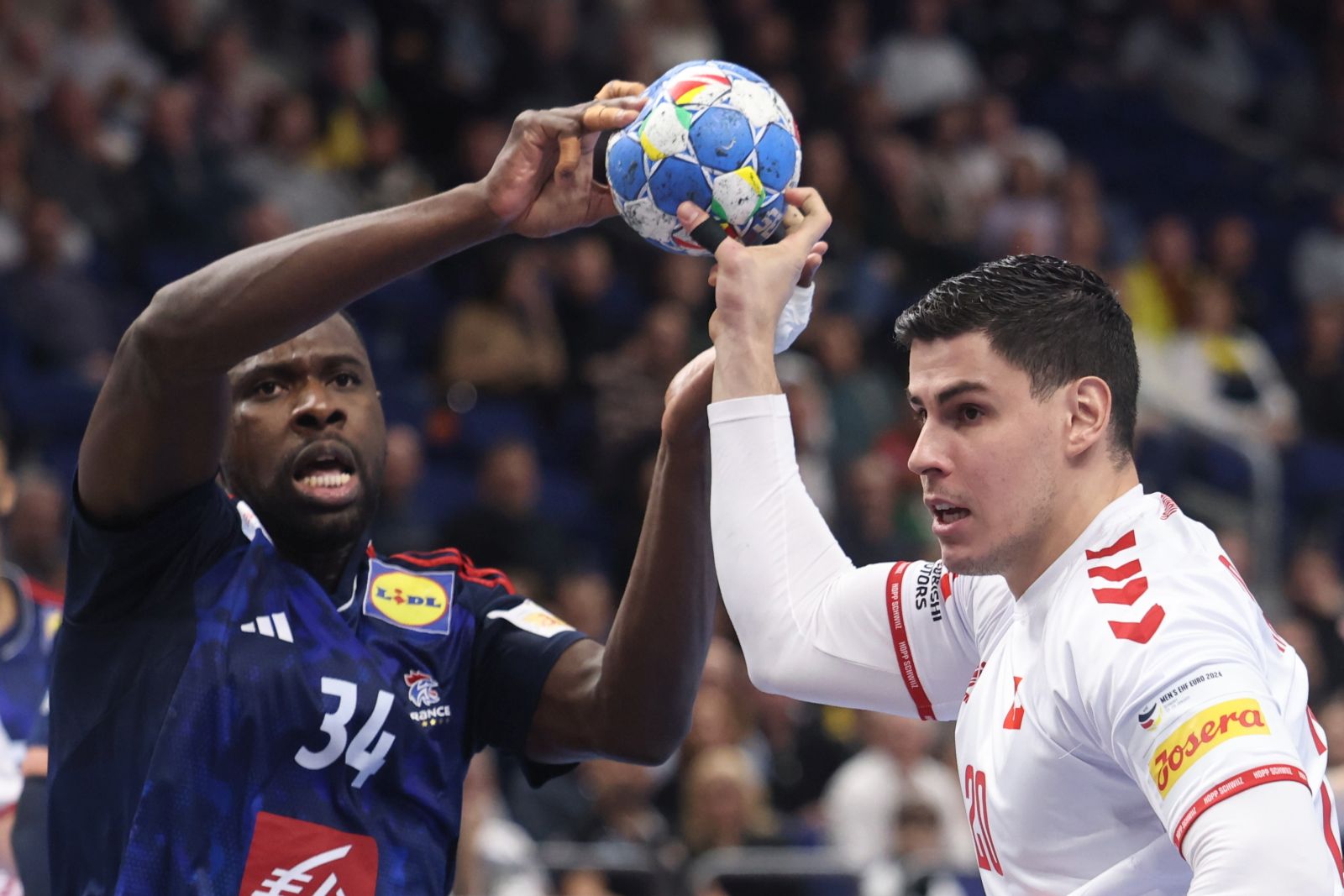 epa11076918 France’s Karl Konan (L) in action against Switzerland’s Luka Maros during the Men's EHF EURO 2024 Handball preliminary round – group A match between Switzerland and France in Berlin, Germany, 14 January 2024.  EPA/CLEMENS BILAN