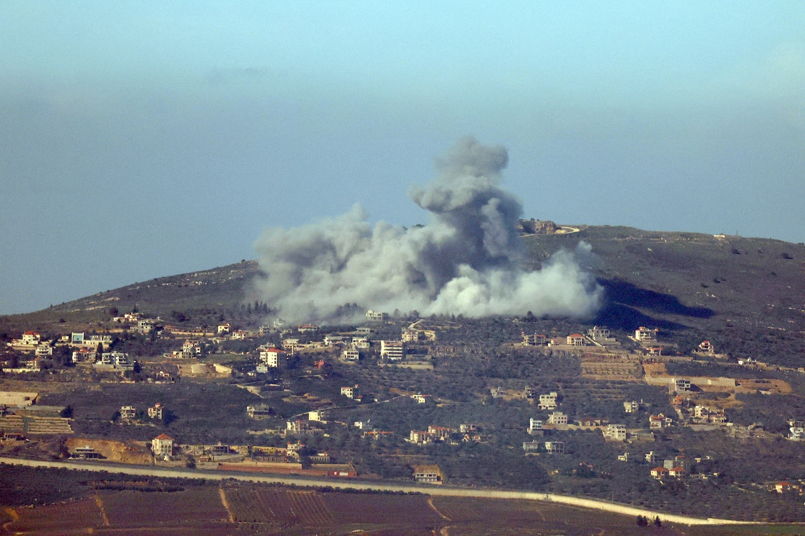 epa11086757 Smoke billows above the south Lebanon village of Odaisseh following an Israeli strike, as seen from the Israeli side of the border, near Kiryat Shmons, Israel, 18 January 2024.  More than 24,400 Palestinians and at least 1,300 Israelis have been killed, according to the Palestinian Health Ministry and the Israel Defense Forces (IDF), since Hamas militants launched an attack against Israel from the Gaza Strip on 07 October, and the Israeli operations in Gaza and the West Bank which followed it.  EPA/ATEF SAFADI