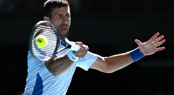 epa11097630 Novak Djokovic of Serbia plays a return shot during his quarter final match against Taylor Fritz of the USA on Day 10 of the 2024 Australian Open at Melbourne Park in Melbourne, Australia, 23 January 2024.  EPA/LUKAS COCH  AUSTRALIA AND NEW ZEALAND OUT