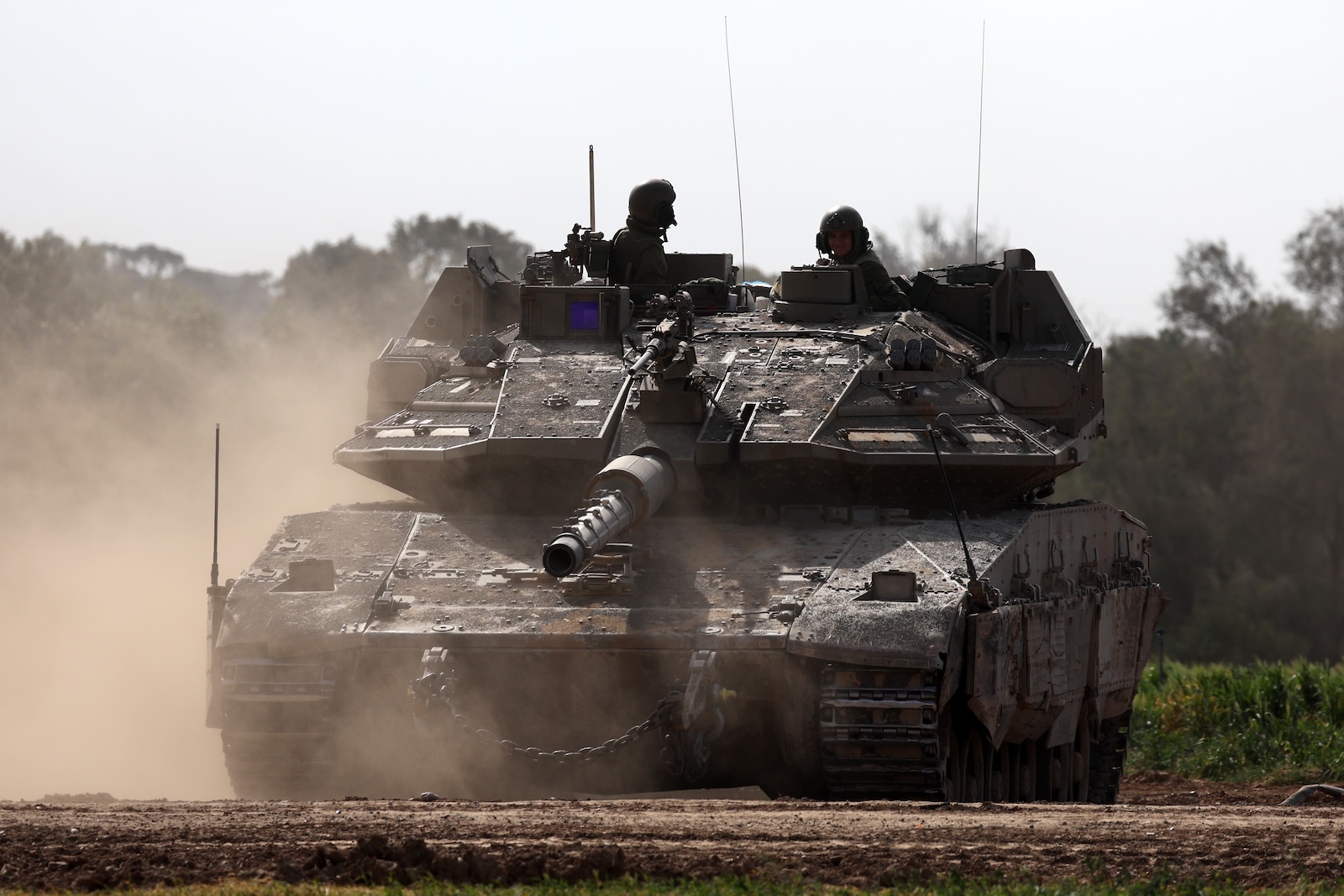 epa11098886 Israeli soldiers on a Merkava tank patrol along the southern part of the border with the Gaza Strip near Khan Yunis, as seen from an undisclosed location in Israel, 23 January 2024. More than 25,400 Palestinians and at least 1,330 Israelis have been killed, according to the Palestinian Health Ministry and the Israel Defense Forces (IDF), since Hamas militants launched an attack against Israel from the Gaza Strip on 07 October 2023, and the Israeli operations in Gaza and the West Bank which followed it.  EPA/ATEF SAFADI