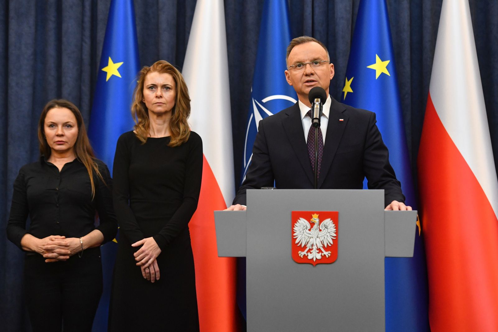 epa11099235 Polish President Andrzej Duda (R) speaks next to Mariusz Kaminski's wife Barbara Kaminska (L) and Maciej Wasik's wife Roma Wasik (C) during a statement at the Presidential Palace in Warsaw, Poland, 23 January 2024. Duda has pardoned the former interior minister, Mariusz Kaminski, and his deputy, Maciej Wasik, who were sentenced to two years in prison for abuse of power, and has requested that the justice minister release them immediately.  EPA/Piotr Nowak POLAND OUT