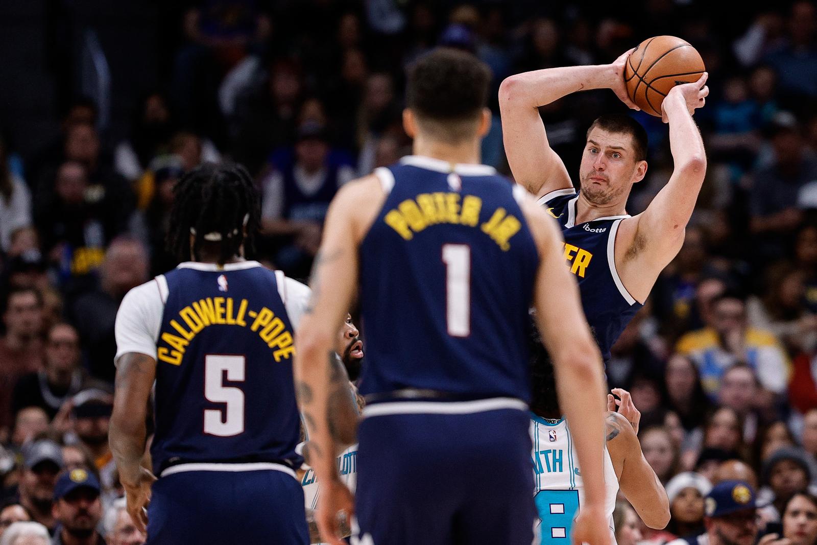 Jan 1, 2024; Denver, Colorado, USA; Denver Nuggets center Nikola Jokic (15) looks to pass the ball as guard Kentavious Caldwell-Pope (5) and forward Michael Porter Jr. (1) watch in the second quarter against the Charlotte Hornets at Ball Arena. Mandatory Credit: Isaiah J. Downing-USA TODAY Sports Photo: Isaiah J. Downing/REUTERS