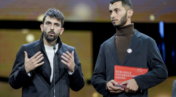 Palestinian Basel Adra, right, and Israeli Yuval Abraham receive the dcoumentary award for "No other land" at the International Film Festival, Berlinale, in Berlin, Saturday, Feb. 24, 2024. (AP Photo/Markus Schreiber)