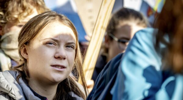 epa10971612 Swedish climate activist Greta Thunberg (L) takes part in a march for climate and justice in Amsterdam, The Netherlands, 12 November 2023. The participants are calling on politicians to take measures against problems such as the climate crisis, racism, biodiversity crisis, poverty and the housing crisis. According to the police, about 70,000 people took part in the march.  EPA/ROBIN UTRECHT