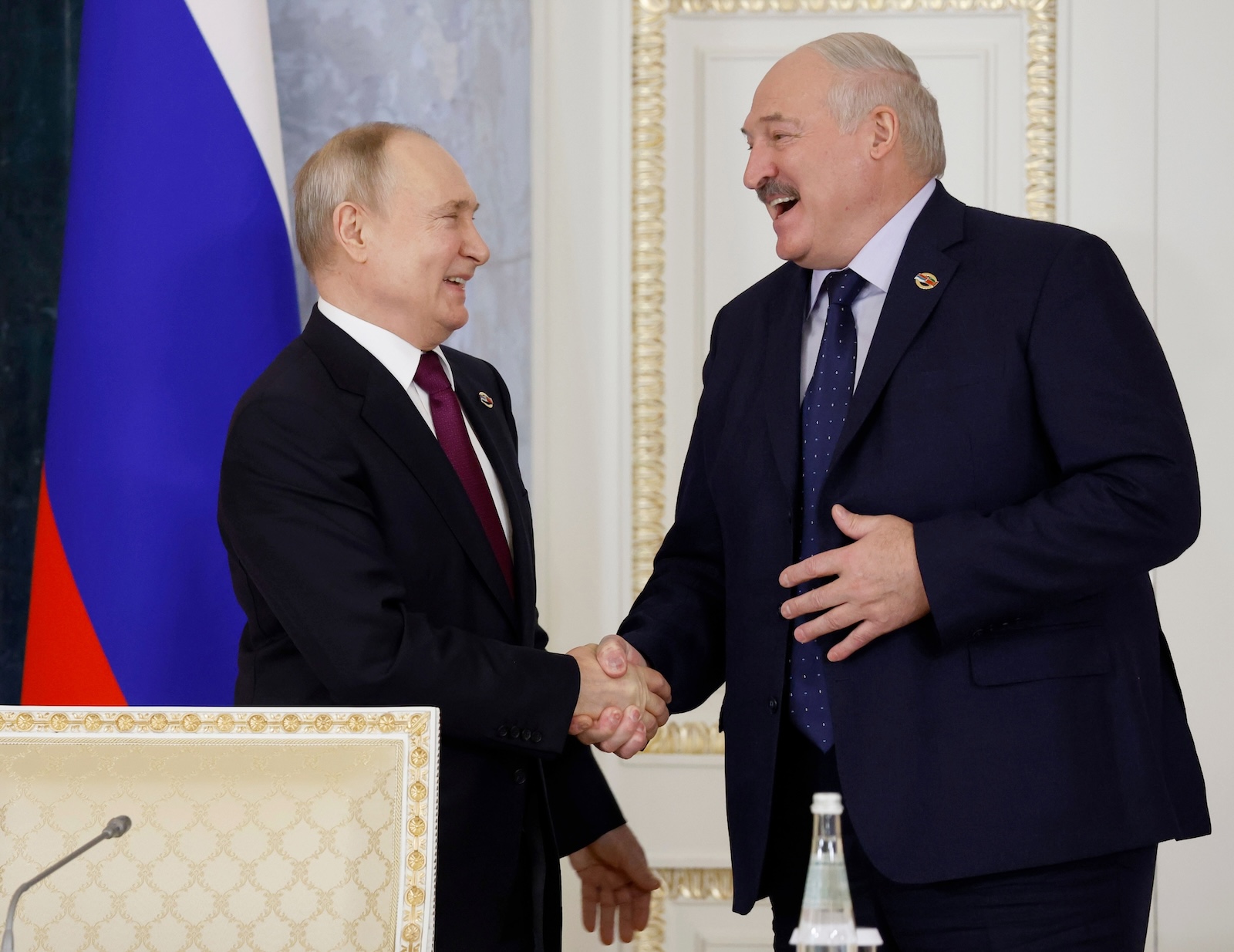 epa11112637 Russian President Vladimir Putin (L) and Belarusian President Alexander Lukashenko react as they shake hands during a meeting of the Supreme State Council of the Russia-Belarus Union State in St. Petersburg, Russia, 29 January 2024. At a meeting of the Supreme State Council of the Union State, Alexander Lukashenko announced the need to intensify cooperation in the field of import substitution and proposed creating a union media holding.  EPA/DMITRY ASTAKHOV / SPUTNIK / GOVERNMENT PRESS SERVICE POOL MANDATORY CREDIT