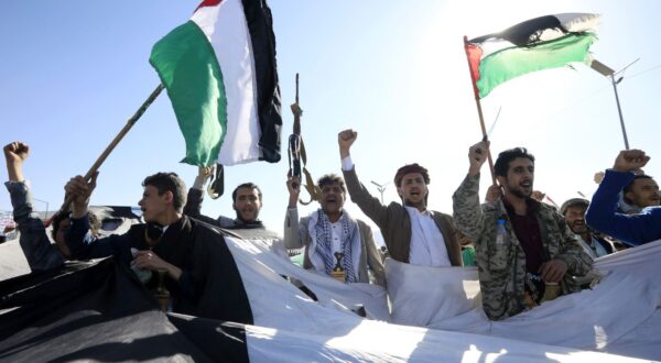 epa11121151 Houthi supporters wave Palestinian flags and shout slogans through gaps in a large-scale Palestinian flag during a protest against US-led strikes on Houthi positions, in Sana'a, Yemen, 02 February 2024. Thousands of Houthis supporters demonstrated in Sana'a to show solidarity with the Palestinian people and protest against US-led strikes on Houthi positions in Yemen. US and British forces have conducted strikes in response to Houthi missile and drone attacks on military and commercial vessels in the Red Sea, the Bab al-Mandab Strait, and the Gulf of Aden since November 2023. In January 2024, the US Department of State designated Yemen's Houthis as a 'Specially Designated Global Terrorist group' due to their increased attacks on shipping lanes. In December 2023, the US Department of Defense announced a multinational operation to safeguard trade and protect ships in the Red Sea in response to the escalation of Houthi attacks.  EPA/YAHYA ARHAB