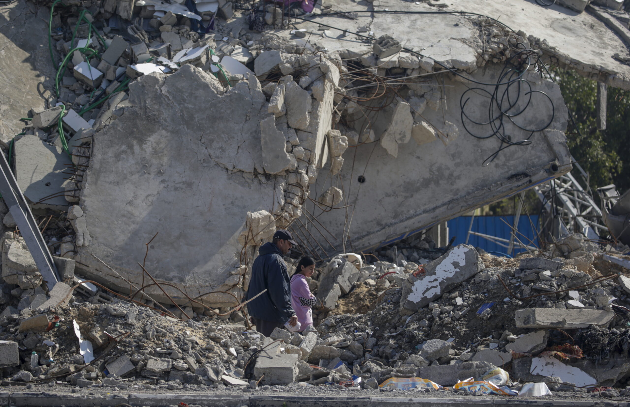 epa11131521 A Palestinian father walks with his daughter next to the rubble of a destroyed house following an Israeli air strike on the Al Maghazi refugee camp, southern Gaza Strip, 06 February 2024. More than 27,000 Palestinians and over 1,300 Israelis have been killed, according to the Palestinian Health Ministry and the Israel Defense Forces (IDF), since Hamas militants launched an attack against Israel from the Gaza Strip on 07 October 2023, and the Israeli operations in Gaza and the West Bank which followed it.  EPA/MOHAMMED SABER
