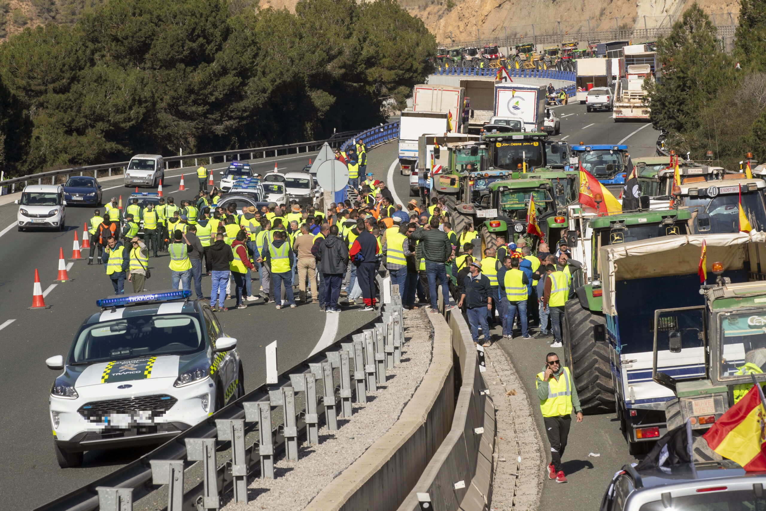 epa11134296 Farmers blocking the Puerto de la Cadena (A-30) negotiate with Guardia Civil officers to allow opening one of the road lanes to traffic in Murcia region, south-western Spain, 07 February 2024. Farmers in Spain keep blocking traffic on some of the country's main highways on 07 February, as they continue their protest against what they say are harmful European agricultural policies, echoing demonstrations in other parts of Europe, including Germany, Belgium and France.  EPA/MARCIAL GUILLEN