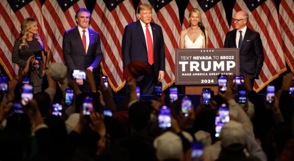 epa11138593 Republican presidential candidate and former US president Donald J. Trump (C) acknowledges his supporters as Republican Governor of North Dakota, Doug Burgum (2-L), his wife Kathryn Helgaas Burgum (L) and New York Jets owner Woody Johnson (R) look on during Trump's campaign hosted caucus night watch party event at the Treasure Island Resort & Casino in Las Vegas, Nevada, USA, 08 February 2024.  EPA/JOHN MABANGLO