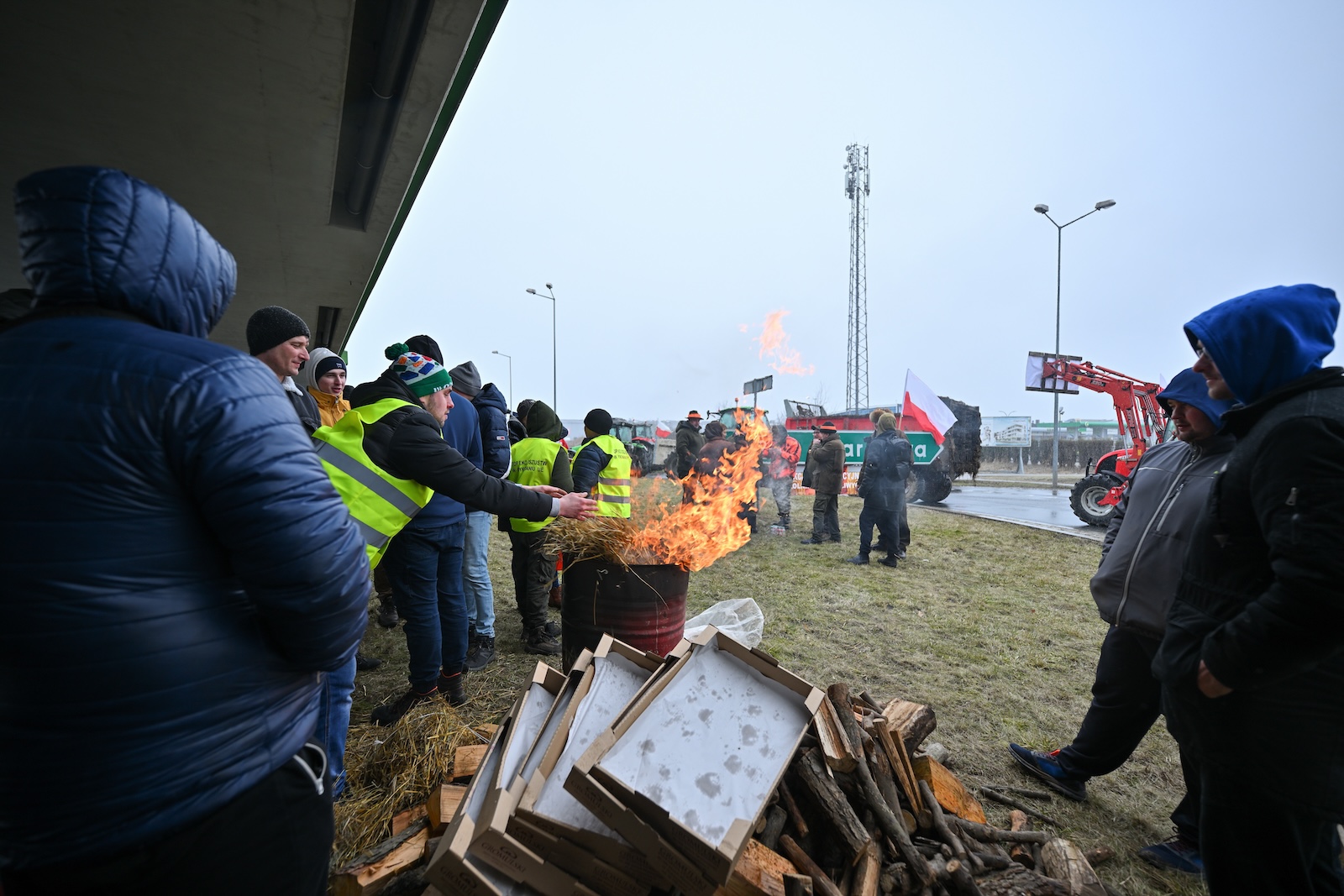 epa11139576 Polish farmers light a fire and block traffic during a protest in Stojadla village, east-central Poland, 09 February 2024. Polish farmers announced a nationwide protest on 09 February against the European Green Deal and the influx of goods coming from Ukraine, expected to last for 30 days.The protest was sparked by the recent decision by the European Commission to extend the duty-free trade with Ukraine until 2025. Farm vehicles, such as tractors, as well as pedestrians blocked roads in different parts of the country.  EPA/PRZEMYSLAW PIATKOWSKI POLAND OUT