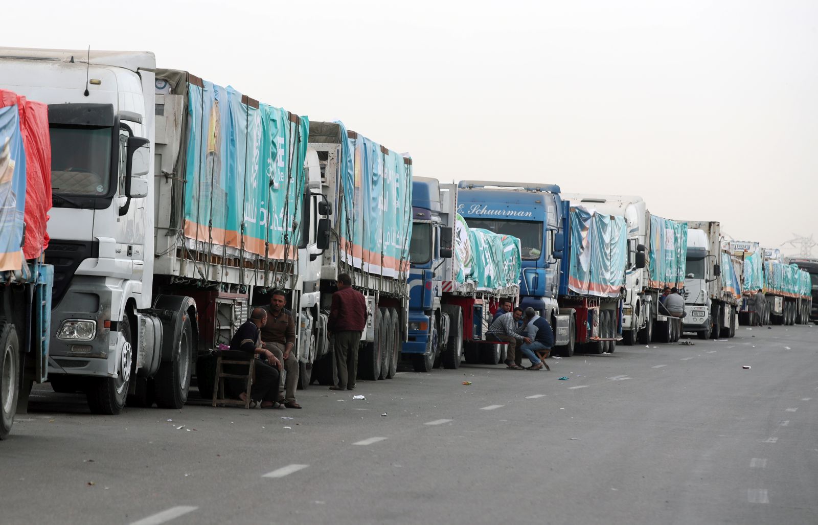 epa11149423 A convoy of trucks carrying humanitarian aid supplies for Gaza waits on the main Ismailia desert road, about 300km east of the Egyptian border with Gaza, on its way to the Rafah crossing, Egypt, 13 February 2024. More than 28,300 Palestinians and over 1,300 Israelis have been killed, according to the Palestinian Health Ministry and the Israel Defense Forces (IDF), since Hamas militants launched an attack against Israel from the Gaza Strip on 07 October 2023, and the Israeli operations in Gaza and the West Bank which followed it.  EPA/KHALED ELFIQI