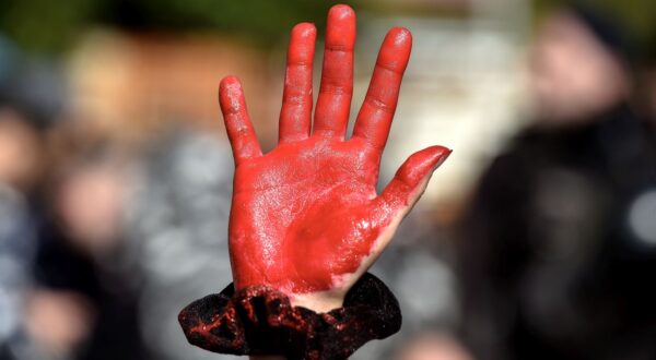 epa11165914 An activist raises her red-painted hand during a protest to demand the opening of Rafah border crossing between Egypt and the Gaza Strip, outside of the Egyptian embassy in Beirut, Lebanon, 19 February 2024. Thousands of Israelis and Palestinians have been killed since the militant group Hamas launched an unprecedented attack on Israel from the Gaza Strip on 07 October 2023, and the Israeli strikes on the Palestinian enclave which followed it.  EPA/WAEL HAMZEH