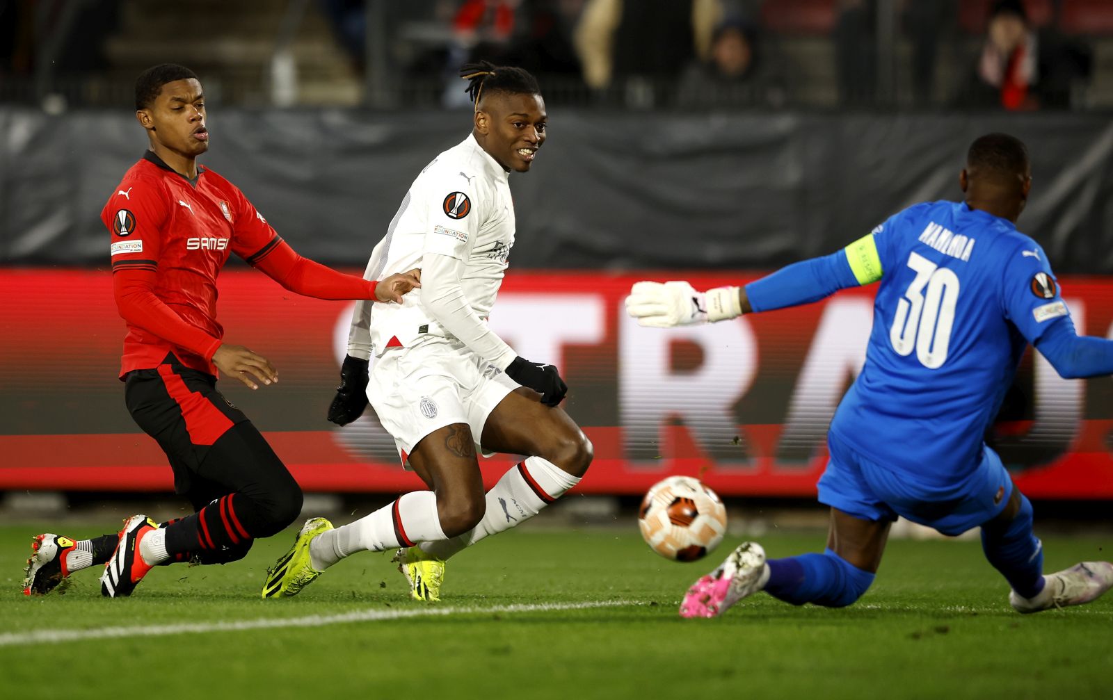 epa11172833 Rafael Leao (C) of Milan attempts to score against Rennes goalkeeper Steve Mandanda during the UEFA Europa League knock- out round play-offs, 2nd leg soccer match between Stade Rennes and AC Milan in Rennes, France 22 February 2024.  EPA/YOAN VALAT