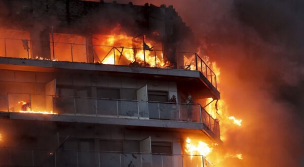 epa11173260 Two people wait to be rescued from a fire of a 14-story residential building in Valencia, eastern Spain, 22 February 2024. At least seven people were injured during the ongoing fire, and two people trapped on a balcony were rescued by firefighters.  EPA/MANUEL BRUQUE