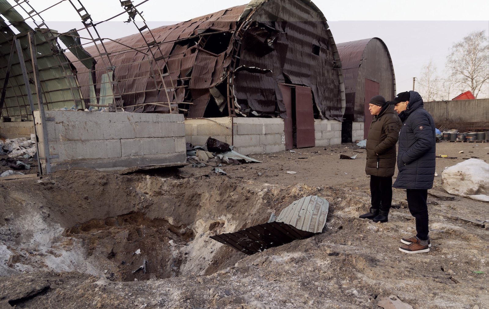 epa11182126 Locals look at a damaged hangar used to store grain after a night rocket attack in Pisochyn, near Kharkiv, northeastern Ukraine, 26 February 2024. amid the Russian invasion. There were no fatalities or injuries, according to the Kharkiv Regional Military Administration. Russian troops entered Ukraine on 24 February 2022 starting a conflict that has provoked destruction and a humanitarian crisis.  EPA/YAKIV LIASHENKO