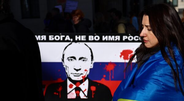 epa11177589 A participant stands next to a banner against Russian President Vladimir Putin during a demonstration in support of Ukraine, on the second anniversary of Russia's invasion of Ukraine, in Berlin, Germany, 24 February 2024. Ukraine on 24 February marks the second year since Russian troops entered its territory, starting a conflict that has provoked destruction and a humanitarian crisis.  EPA/FILIP SINGER